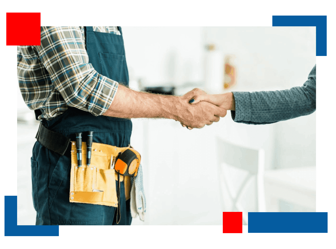 Two people shaking hands over a table.